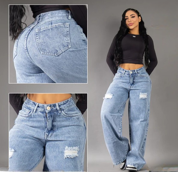 Modelo posando de frente con jeans anchos tipo baggy en tono azul medio, con detalles de rotos en las piernas y tiro alto, resaltando la silueta colombiana.