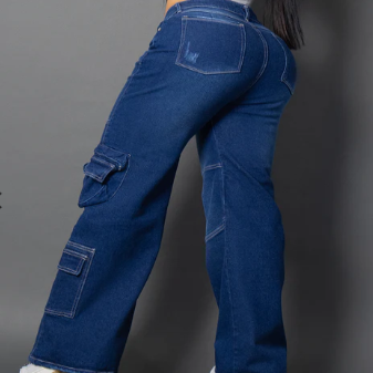 Vistas frontales de unos jeans cargo en denim azul oscuro con costuras blancas en contraste, múltiples bolsillos utilitarios en las piernas y corte de bota ancha.