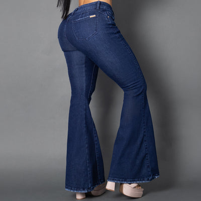 Primer plano de jeans colombianos bota campana en denim azul oscuro, destacando las costuras verticales frontales que nacen desde la cintura para alargar la silueta y el tiro alto ajustado.