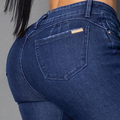 Primer plano de jeans colombianos bota campana en denim azul oscuro, destacando las costuras verticales frontales que nacen desde la cintura para alargar la silueta y el tiro alto ajustado.