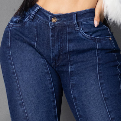 Primer plano de jeans colombianos bota campana en denim azul oscuro, destacando las costuras verticales frontales que nacen desde la cintura para alargar la silueta y el tiro alto ajustado.