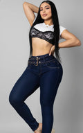 Una modelo de Vengi Fit posa con unos jeans de lavado oscuro de talle alto con un cinturón integrado y un detalle decorativo en la pretina.